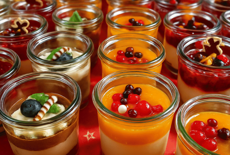 Hausgemachte Desserts im Glas, darunter Schokomousse und fruchtige Cremes, für ein Catering-Buffet in Uelzen.