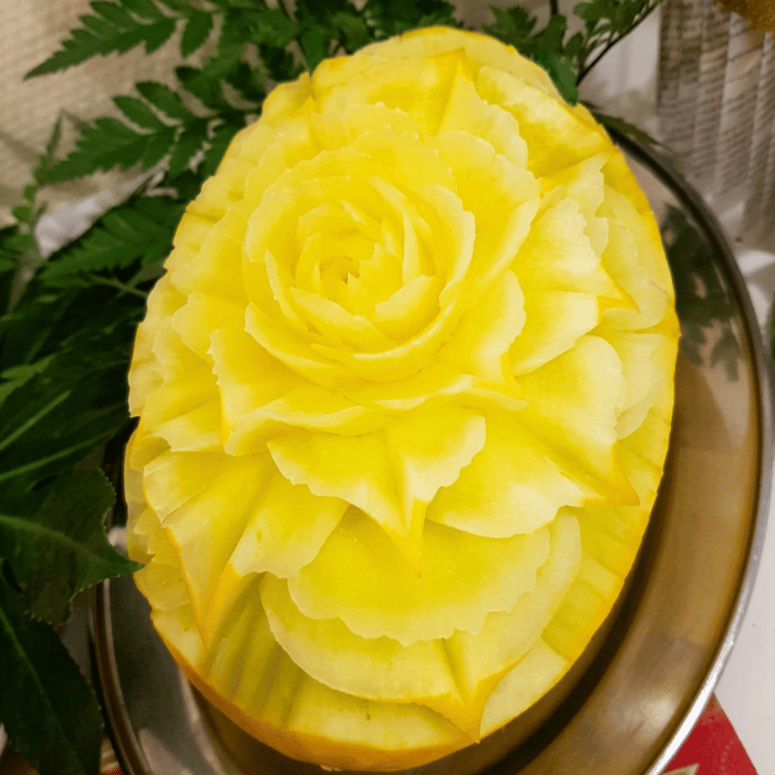 Kunstvoll geschnitzte Honigmelone mit individuellem Muster, serviert als exklusive Dekoration und Buffet-Highlight für Hochzeiten bei Barth Catering in Uelzen.